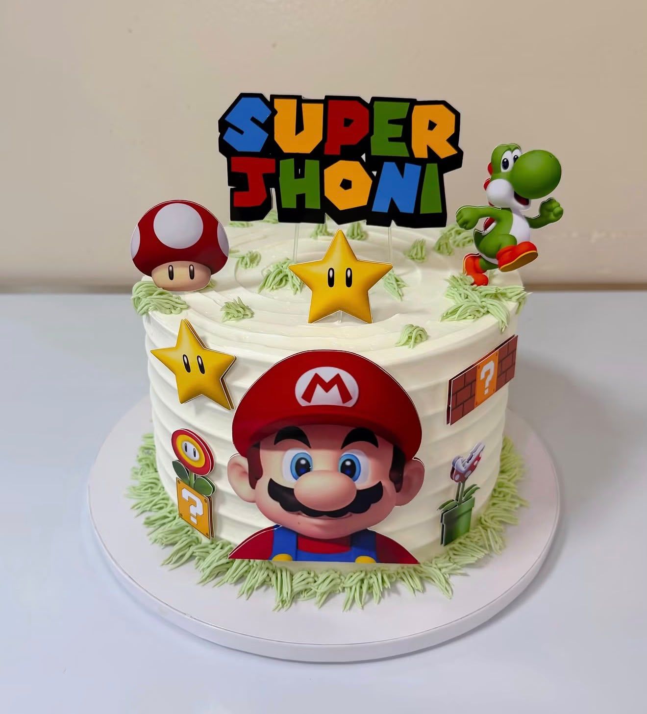 Tarta de cumpleaños personalizada de temática Super Mario con estrellas y césped de crema